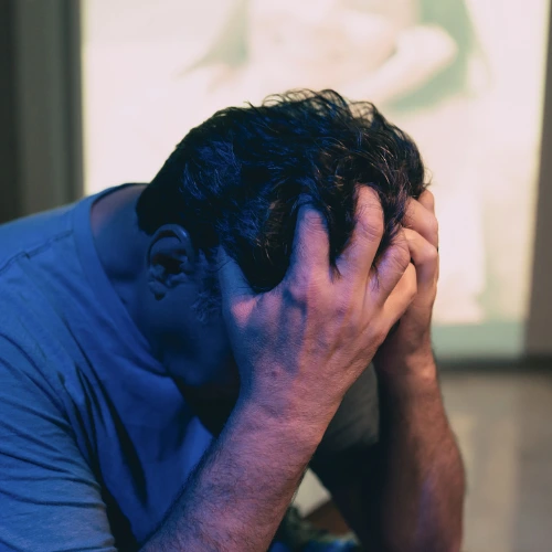 man holding head due to loneliness