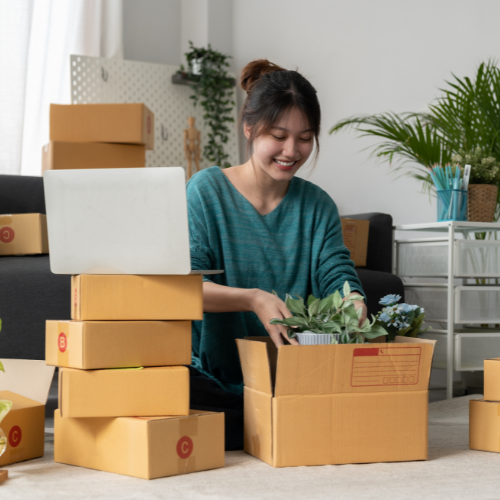 woman packing a small plant in a box