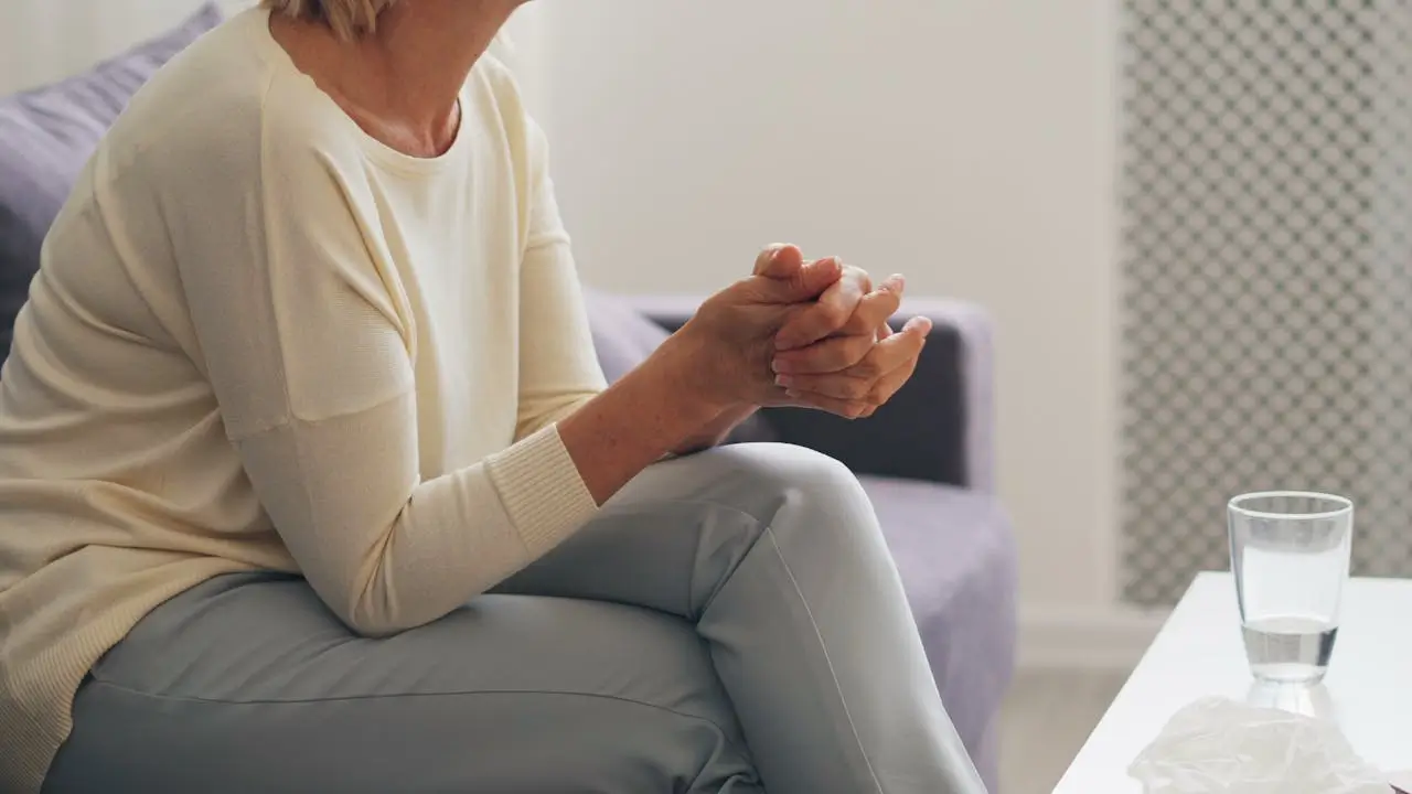 woman sitting on a couch with her hands on her lap